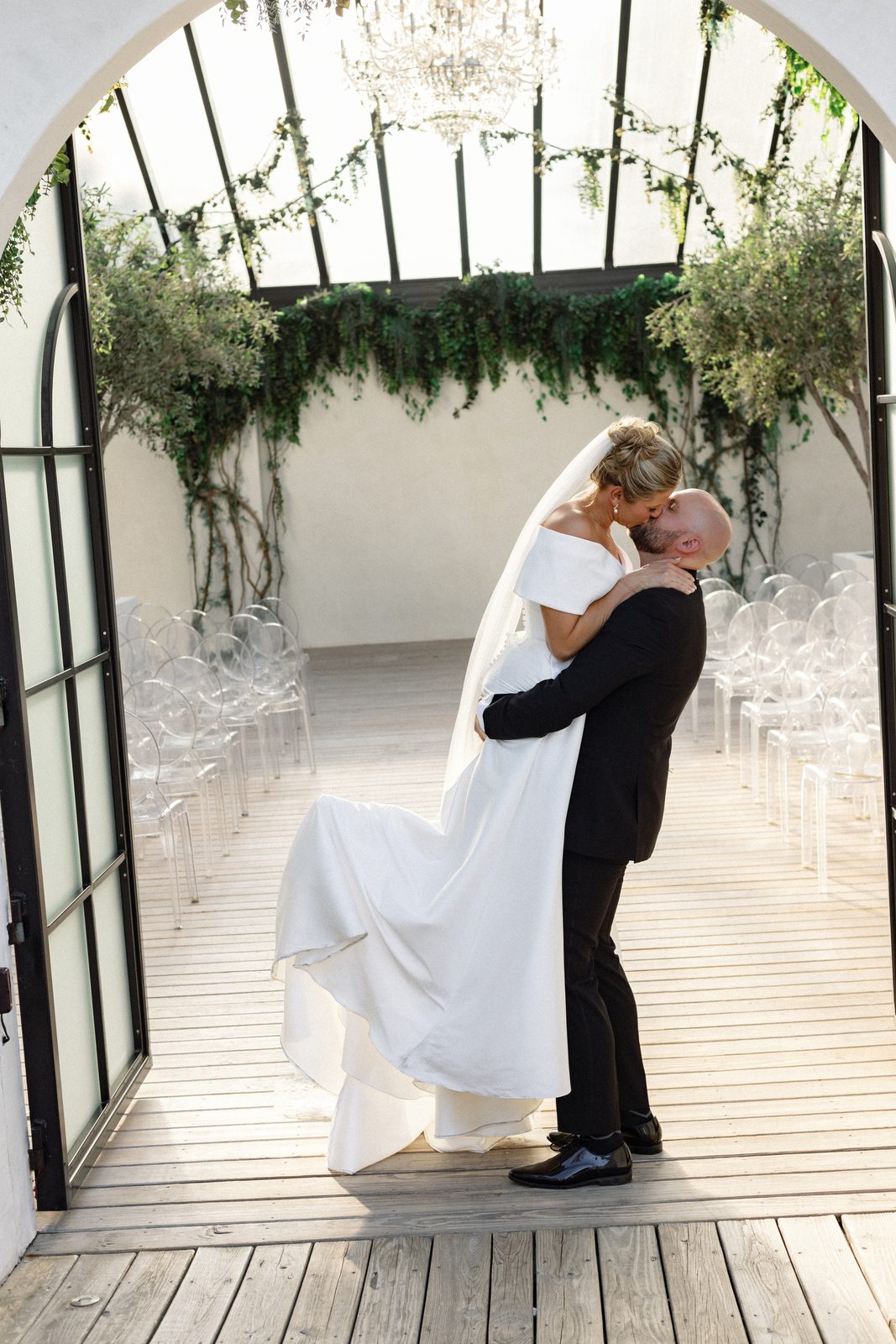 Katie and Mark under the arched doorway of the glass ceremony pavilion